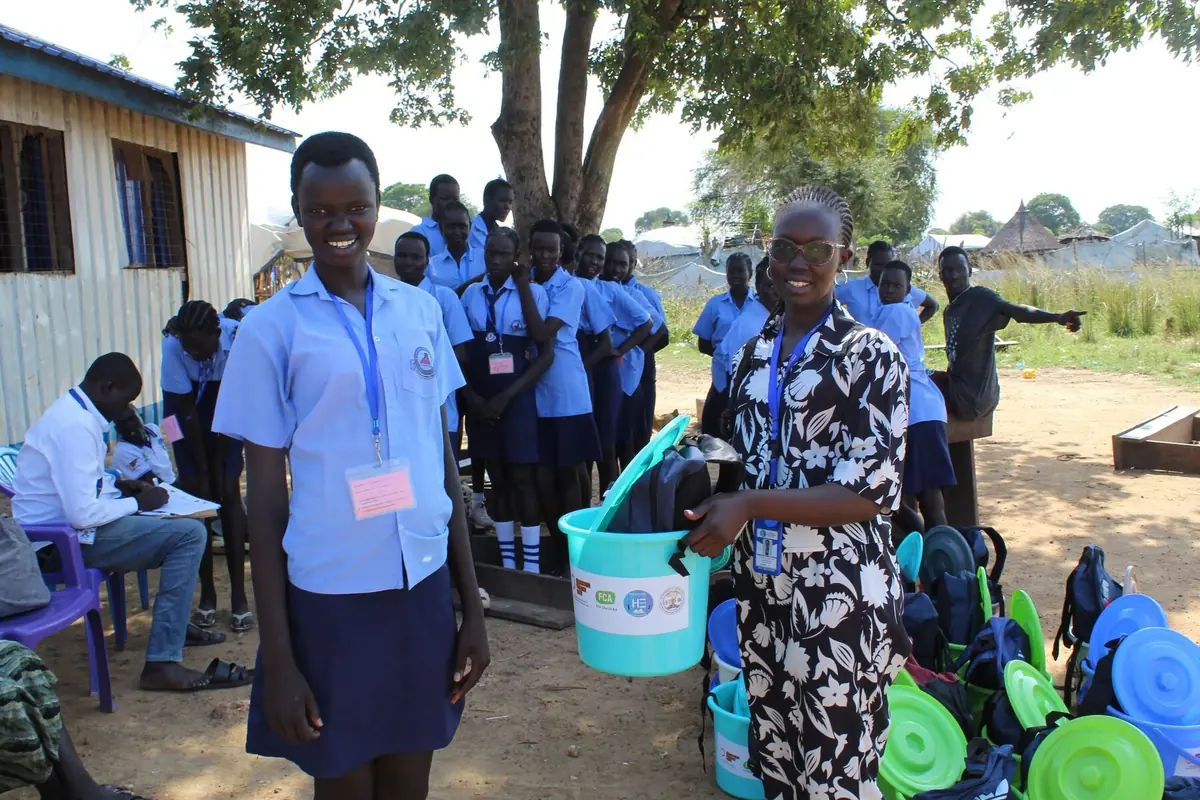 A schoolgirl and HESS team member during a dignity-kit distribution