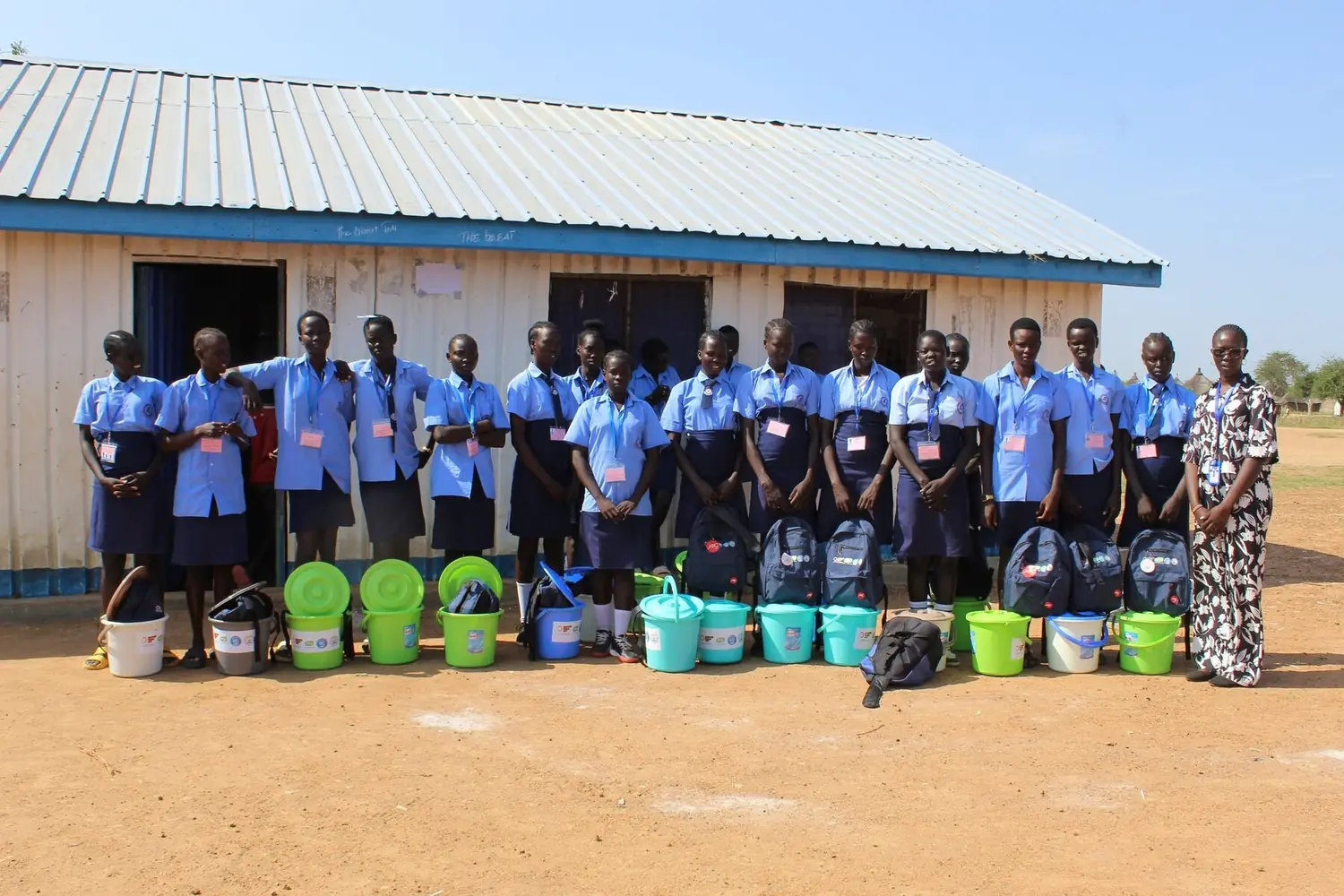 Schoolgirls and HESS staff during a dignity-kit distribution